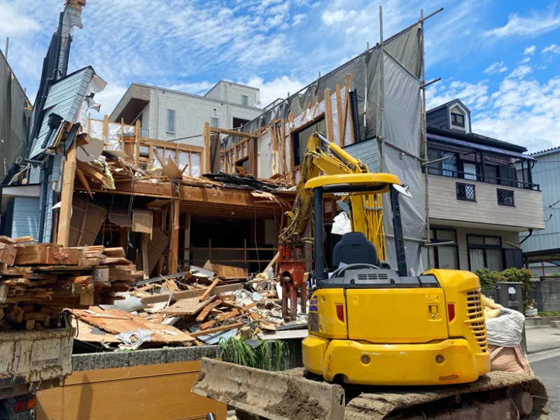 油圧ショベル（重機）を使用して住宅の基礎や構造体を慎重に解体する本体工事の様子