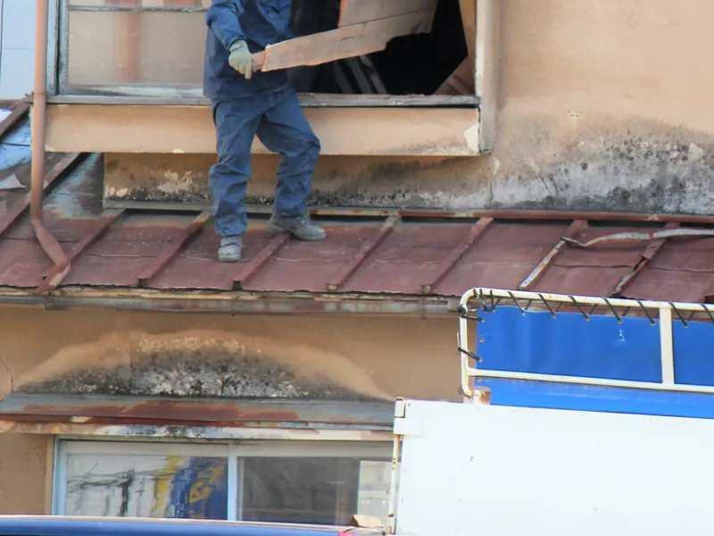 職人が手作業で瓦を一枚ずつ剥がしていく屋根の分別解体作業の様子