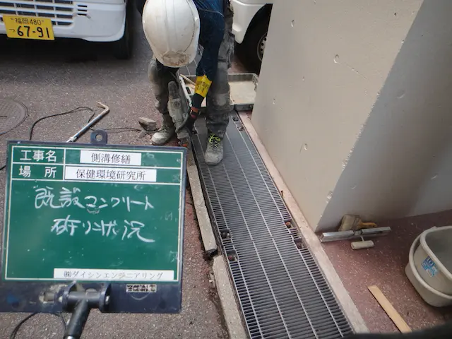 電動はつり機で側溝周りの既設コンクリートを撤去する状況