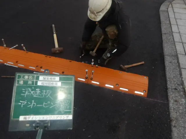 減速板をアンカーピンで固定する設置作業