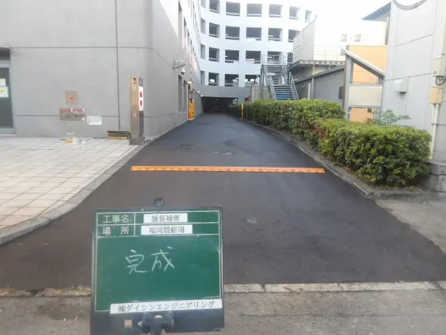 舗装補修と減速板設置が完了した駐車場進入路