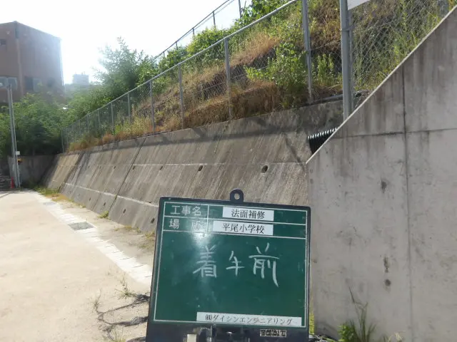 補修前の法面、草の根元で土が露出した状態