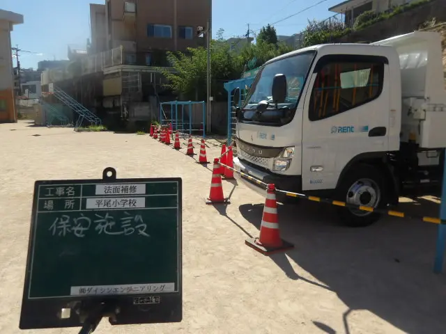 カラーコーンとバーで区画した工事車両の作業エリア