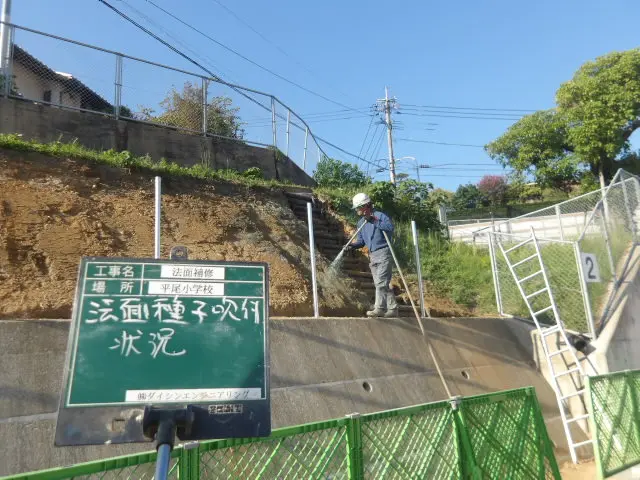 ホースによる法面の種子吹付作業